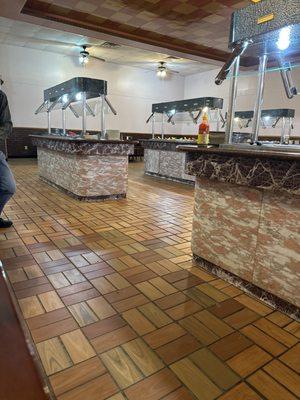 Buffet tables in the back of restaurant behind a wall as to not be seen before you pay.