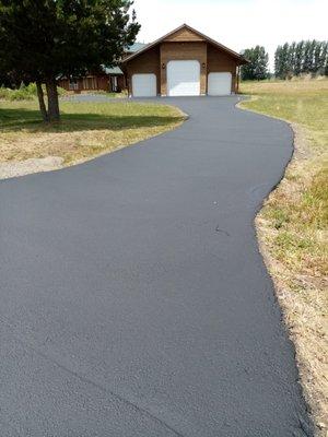 Crack filled, patched and sealcoated driveway.