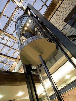 Round glass elevator for luxury homes and commercial buildings.