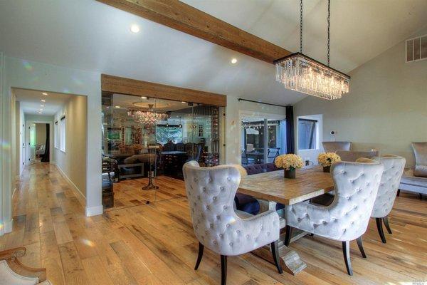 After. New floors, wrapped beams with chandelier, and unusable space turned into wine room.