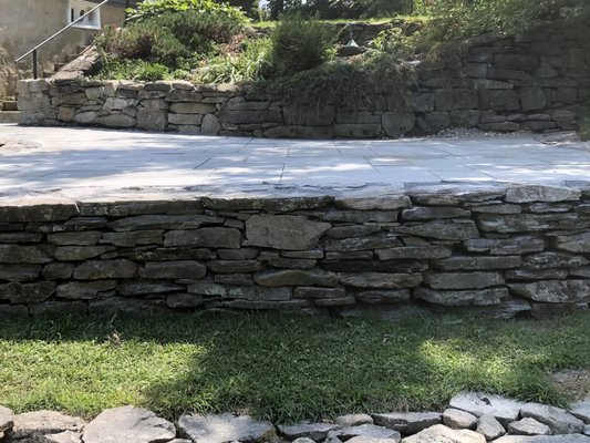 Stone retaining wall with bluestone patio