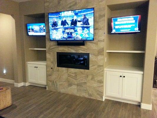 Control4 installation operating 3 TVs w/ Sonos Playbar and rear surround speakers - custom cabinets by Elroy with J.C. Custom Designworks