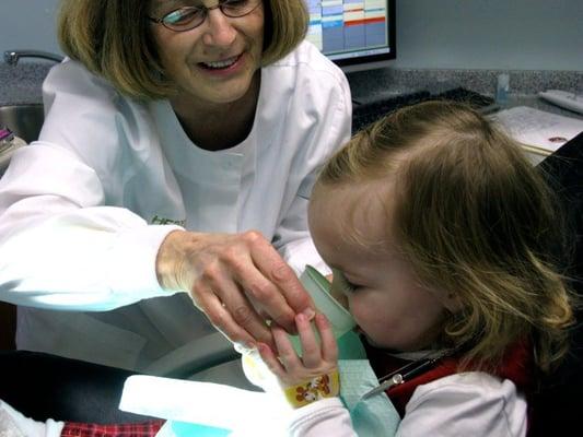 A hygienist works with a pediatric patient.