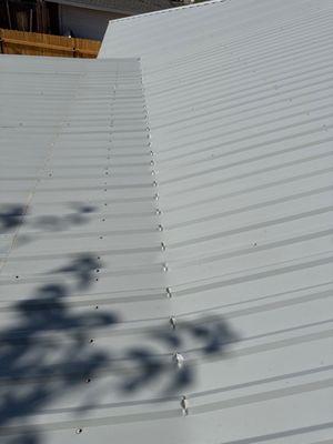 Numerous holes created by bending metal roof done by installation