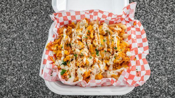 Crispy fries topped with shredded cheddar cheese, cut up fried chicken tenders and drizzled with Ranch Dressing; Sprinkled with Texas Pete H