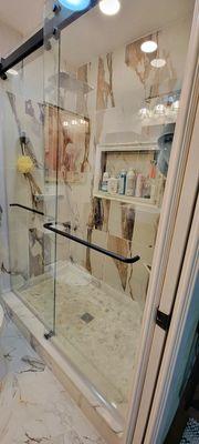 Custom bathroom remodel and design with niche, corner bench, barn style sliding, frameless shower doors.