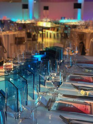 Decorative acrylic "v" shapes as centerpieces in transluscent blue.