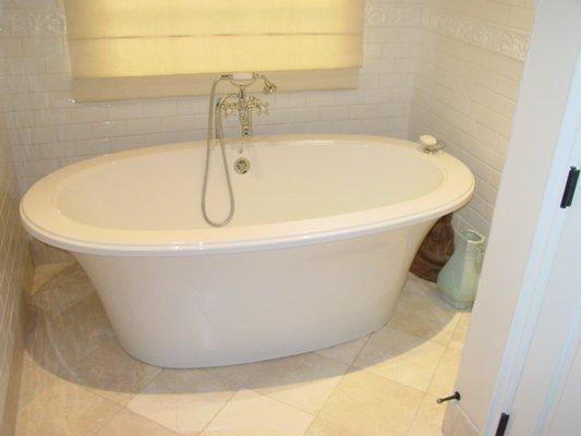 Free Standing Tub with Subway Tile Surround and Stone Floors.