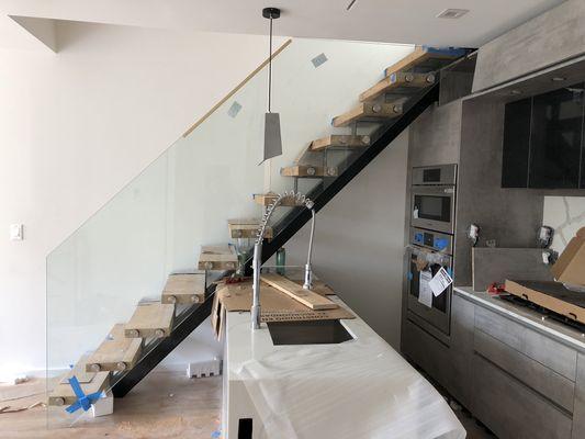 The beautiful new kitchen, floating wooden staircase and glass railing installed