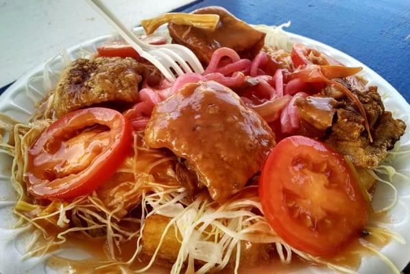 Chicharron con yuca. Fried pork rinds and cassava (fried or boiled) topped with cabbage, pickled veggies.