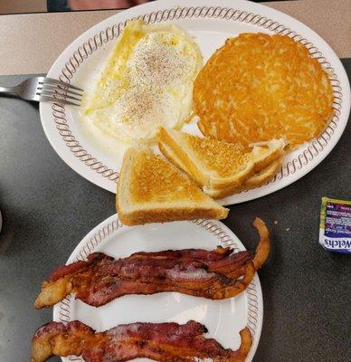 Eggs over easy, crispy hash browns and bacon. Perfect!