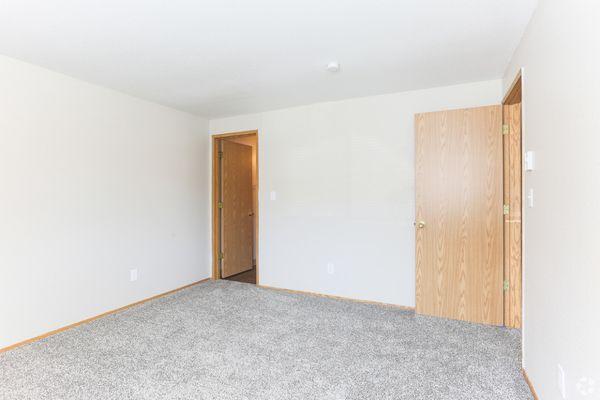 Showing the other half of the master bedroom. The left door leads to the hallway, and the right to an en suite bathroom.