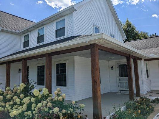 Before and After:  We sprayed this vinyl exterior white and we stained the deck and new posts by hand.