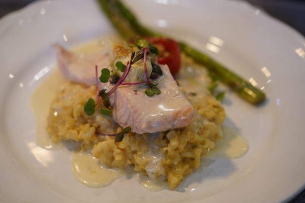 Poached salmon with white wine sauce over a bed of risotto