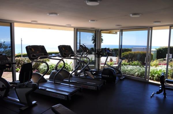 The gym that looks out at the ocean with 2 large sliding glass doors