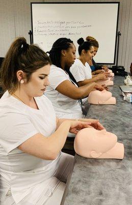 Skin Care Students working on their massage techniques@ Florida Dermal Institute