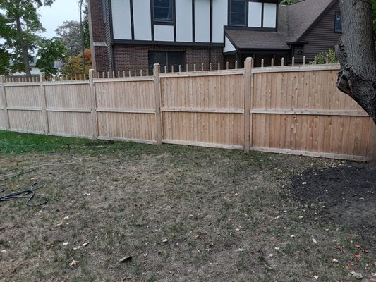 Stockade fence divides the two houses.