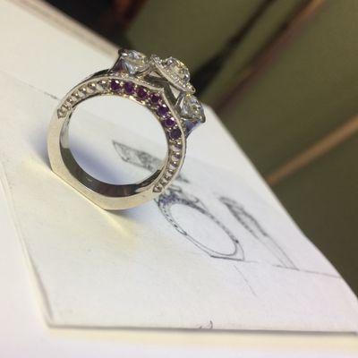 Custom made ring with purple diamonds and hand drawing in background.