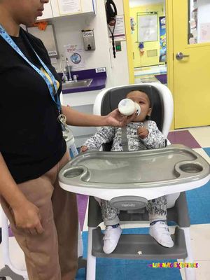 He's crying being fed his milk on a high chair after I explained even in the first day to hold him while feeding milk