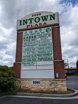 Intown Plaza street sign with list of tenants (retailers/restaurants) on Buford Highway.