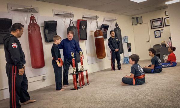 American Kenpo Karate student showing his West Coast Karate Championships trophies.