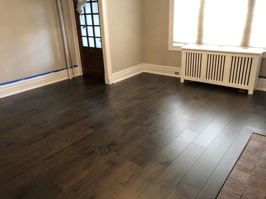 Existing hardwood and subflooring removed, new plywood with leveling installed. And Prefinished engineered wood floor installed on top.