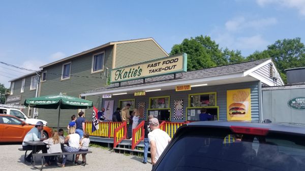 Fast Food Take Out is behind store on side street. Dirt parking lot runs along side of building.