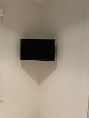 TV wall mounting in a corner on a swivel arm mount. Cabling and power hidden in wall or behind TV.