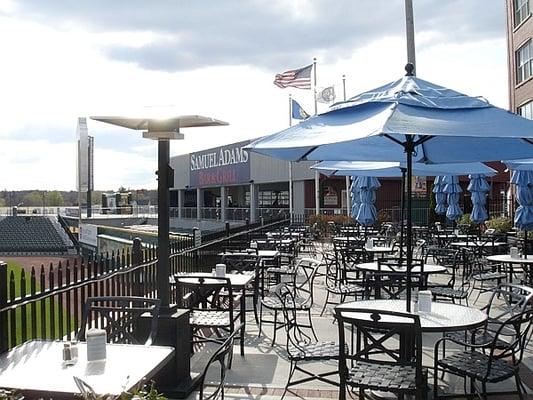 Patio tables, the Samuel Adams Bar & Grill (inside the park) can be seen in the background