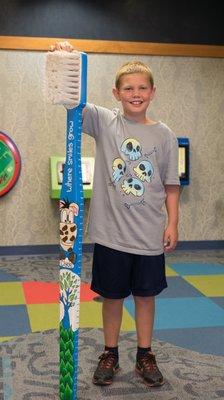 Our friend with our big Where Smiles Grow Toothbrush!