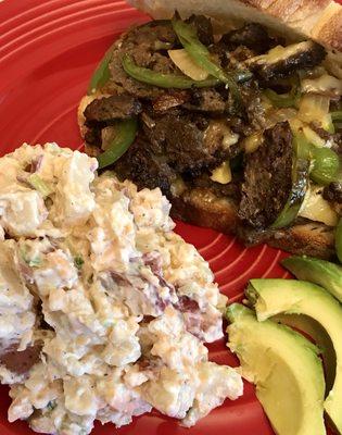 Grilled Steaktan (Seitan) with onions, peppers and plant-based cheese and twice baked potato salad.