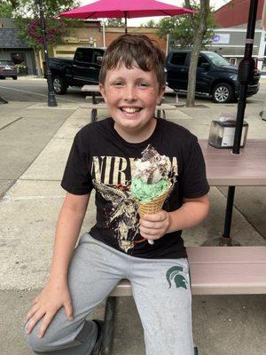 Double scoop waffle cone with mint chocolate chip on bottom and chocolate/vanilla swirl on the bottom