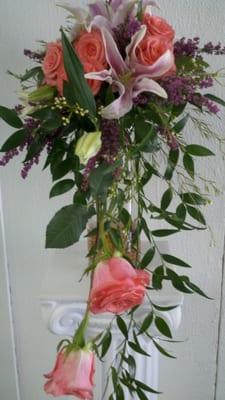 Cascading bouquet with lilies and coral roses.