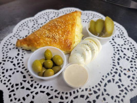 Cheese Burekas, served with pickles and olives