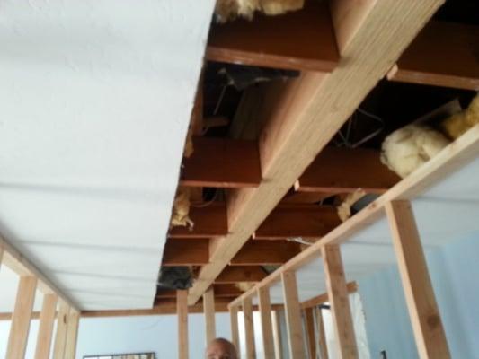 This large beam eliminates the need for the weight bearing wall below.  Setting it flush with the ceiling allows a flat lid.