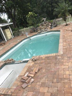 A pool in the process of getting a spa, tile, and pavers added.