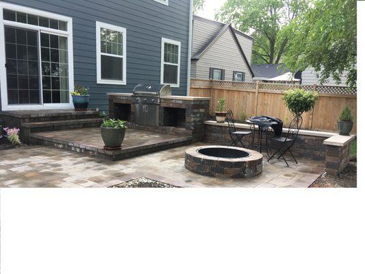 Multilevel patio with outdoor kitchen, fire pit and seat walls.