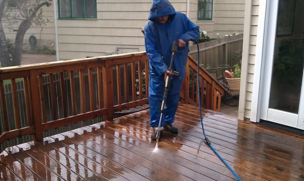 Pressure washing a deck before sanding and staining.