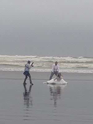 Photographer capturing adventurous wedding couple in the waves!