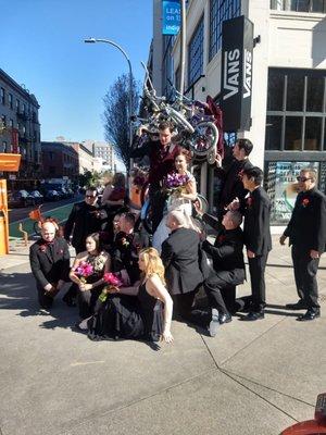 Entire wedding party along a bike statue in downtown Portland, Oregon