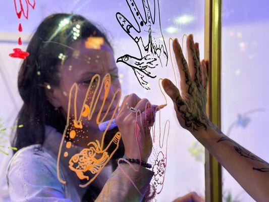 Sheila Darcey tracing Louis' hand during the performance art piece of her event, 'A Portal For Healing'.