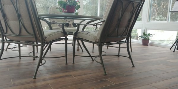 Room design with wood like porcelain tile installed in a sunroom