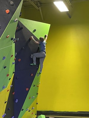 Rock climbing wall with foam pit below.