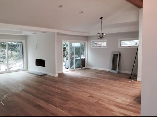 This is the same den / dining room area that was in the before photo.  Alex raised the ceiling, put in a modern fireplace, hung the lights..