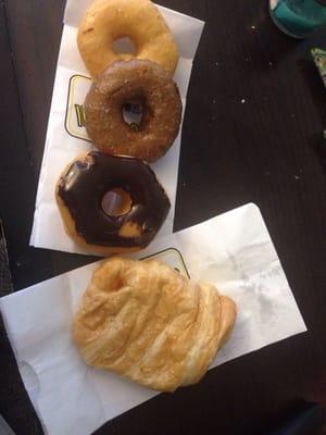 Glazed, blueberry, and chocolate glazed donuts and a ham & cheese croissant.