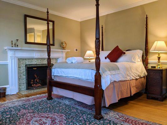 The bedroom of Room 28 features a gas fireplace within the historic fireplace.