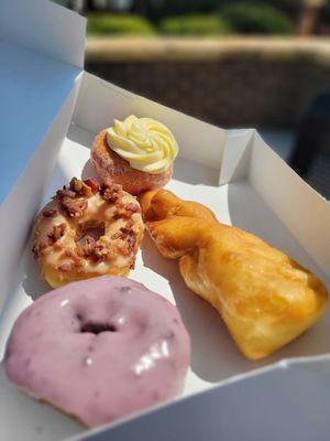 Double Blueberry, Glazed Long John, Maple Bacon, and  a Strawberry Cheesecake donuts.