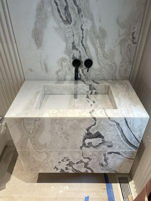 Custom floating integrated marble sink with full backsplash