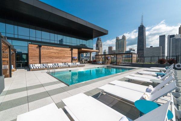 Resort-inspired sundeck featuring an outdoor pool, private cabanas, and outdoor grilling stations with panoramic views of Chicago's skyline