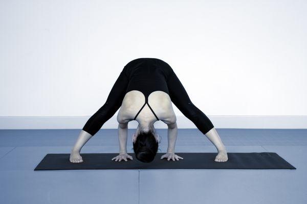 Use gravity to stretch your neck and spine in Prasarita Paddotanasana (Wide-Legged Forward Bend Pose).